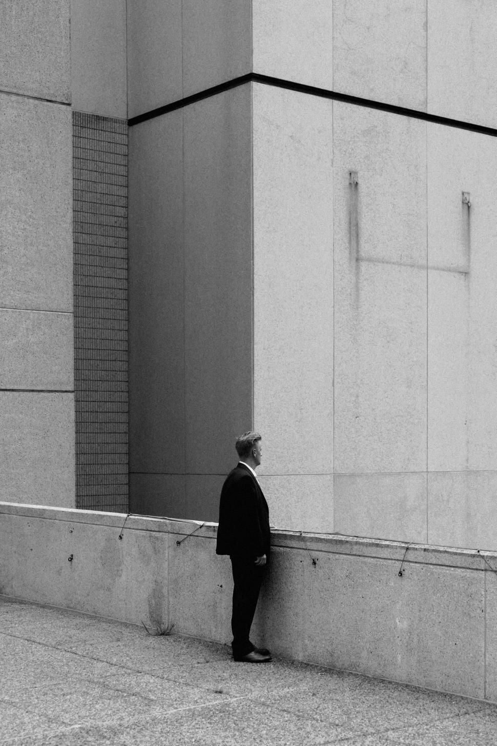 A man in a suit against a wall